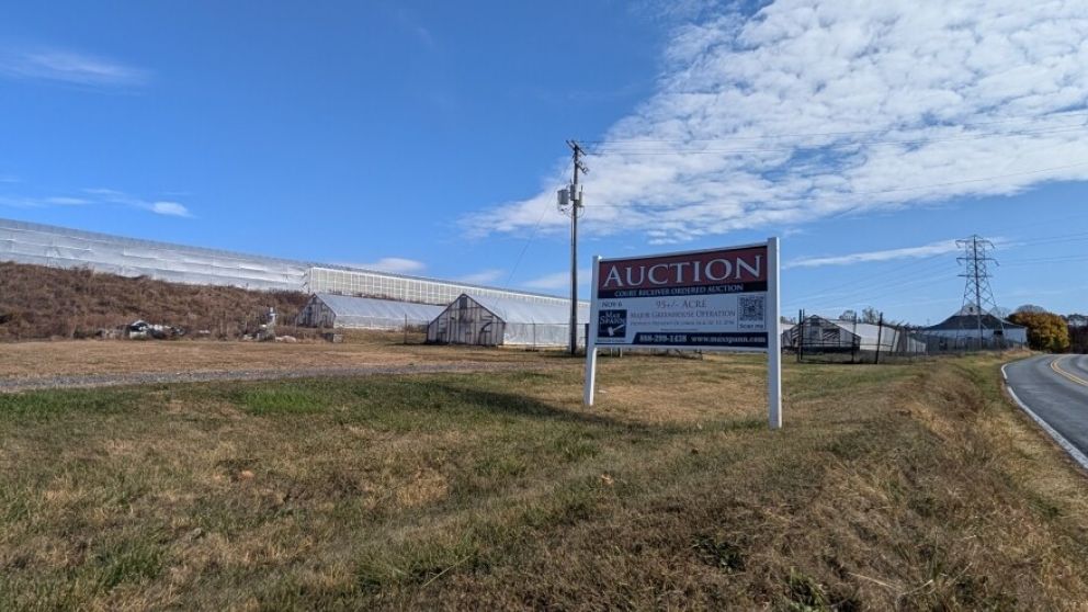 The former Dan Schantz Greenhouse with a sign advertising its auction Wednesday