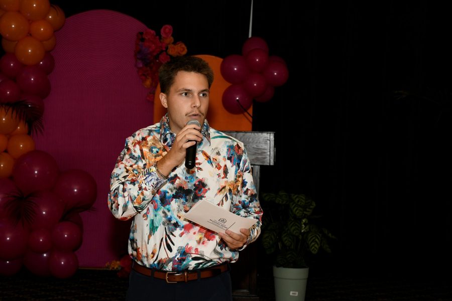 Travis Buman with a microphone at a Nebraska Masonic Home Foundation benefit auction