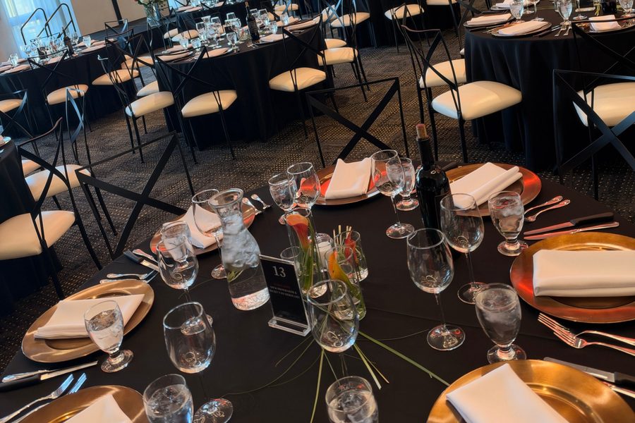 Black and gold table settings ready for a nonprofit gala dinner and auction